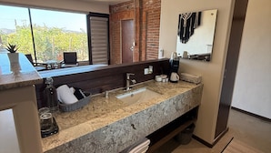 Un baño moderno con un lavamanos grande, un espejo y vistas al exterior.