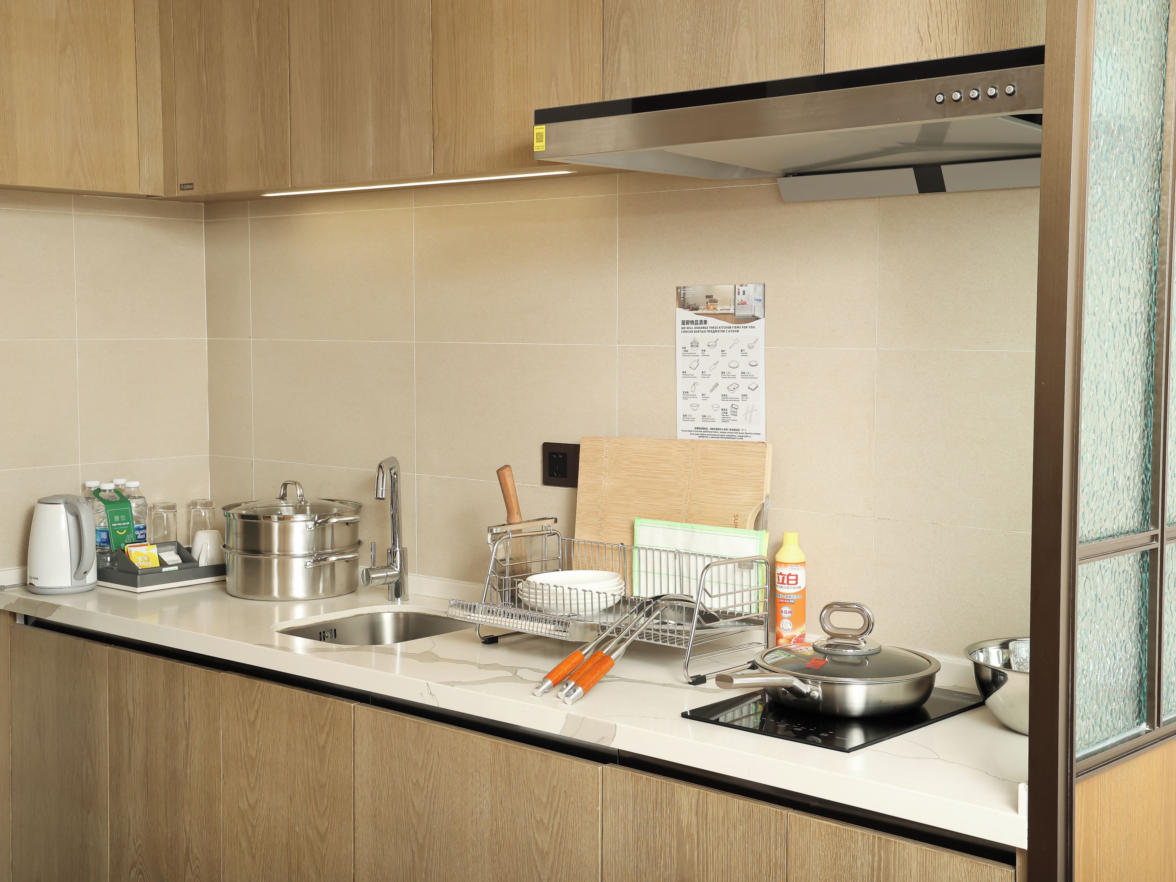 Una cucina moderna con lavello in acciaio inossidabile, forno integrato e piano di lavoro in legno.