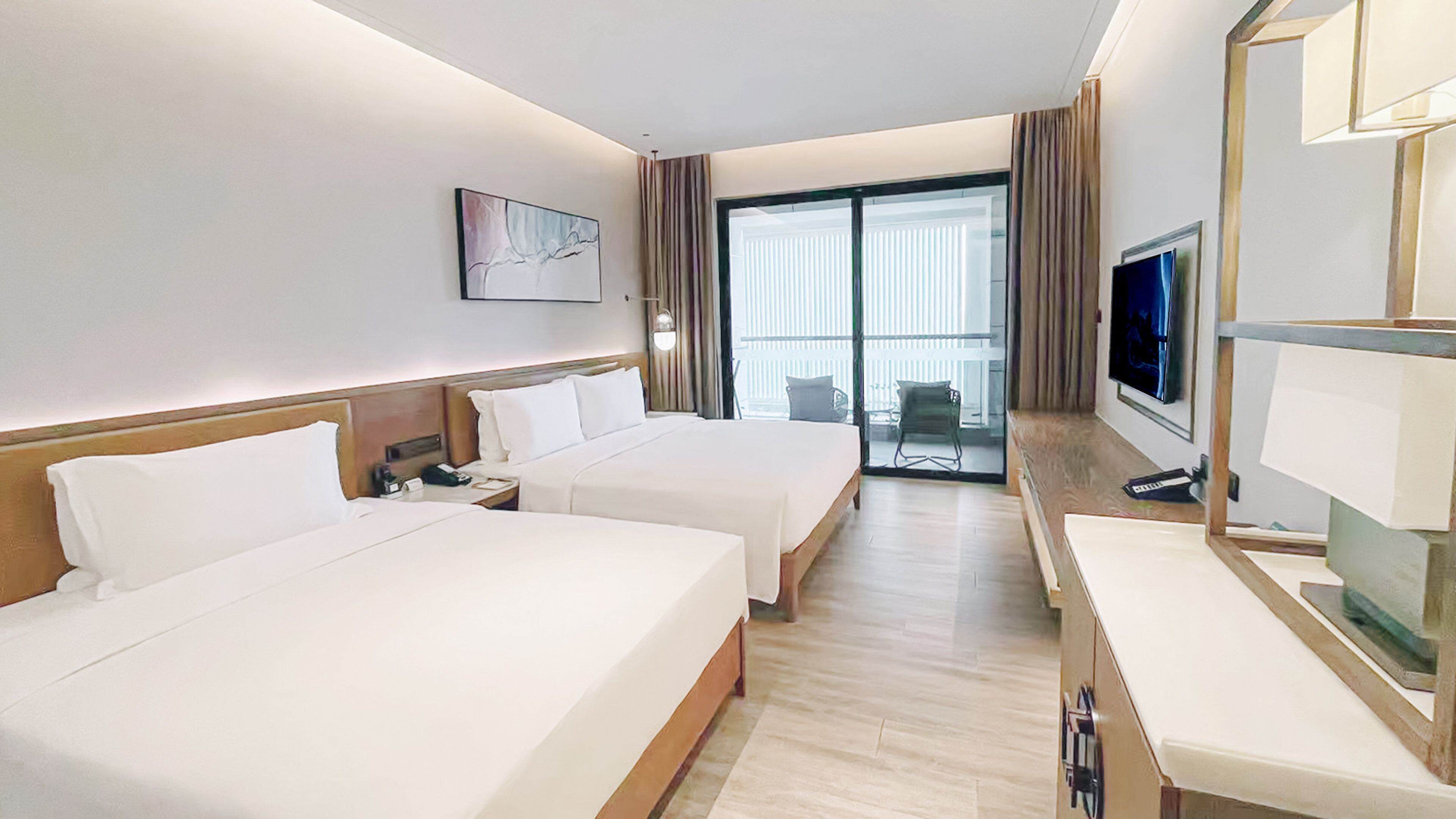 Een hotelkamer met twee bedden, een televisie, een bureau en een balkon met uitzicht.