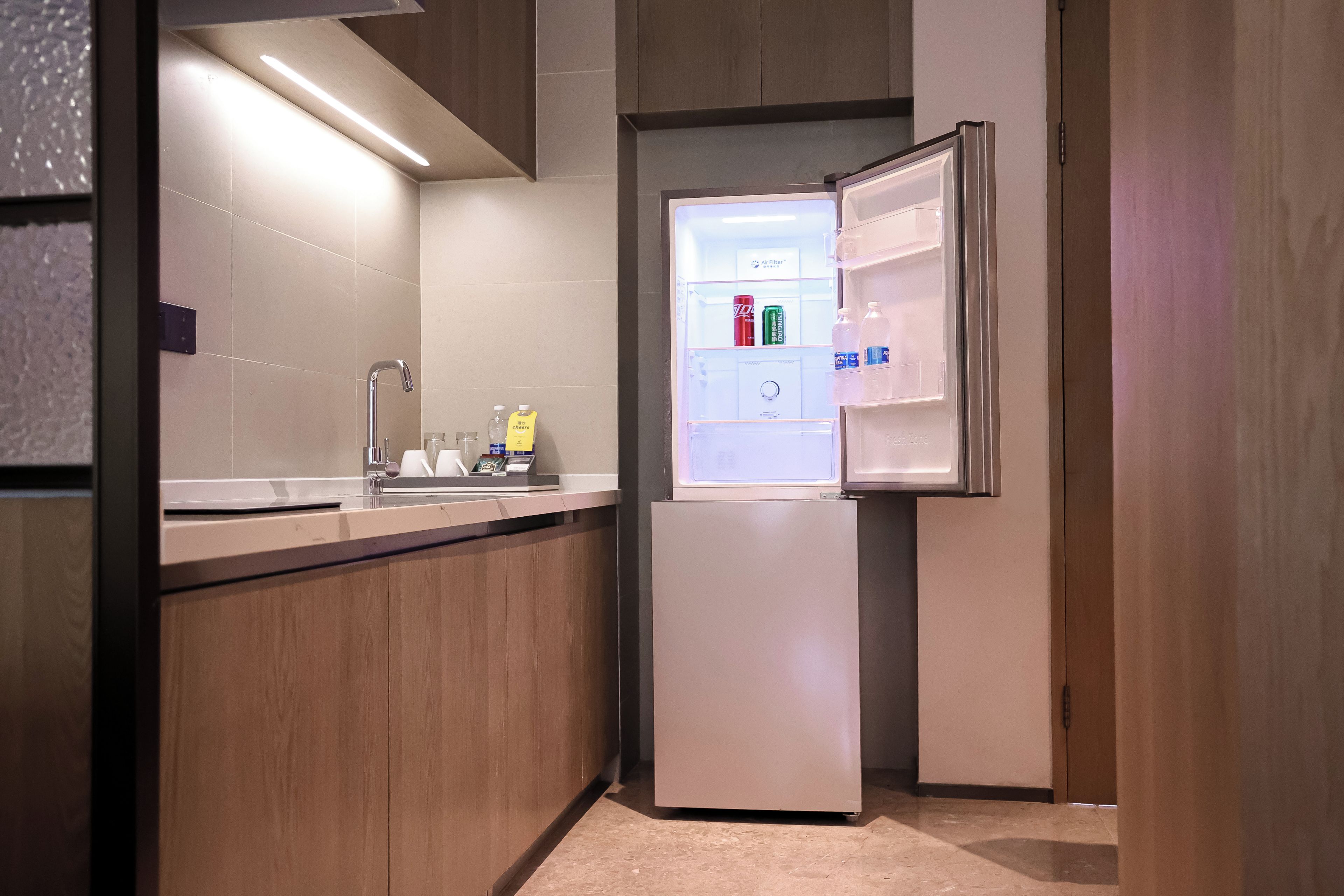 Una cocina moderna con un refrigerador empotrado, un lavamanos y una encimera.