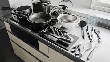 A kitchen counter with various cooking utensils, pots, and pans.