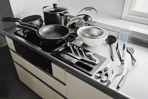 A kitchen counter with various cooking utensils, pots, and pans. - THE BEEHIVE AIOI (Otaru)