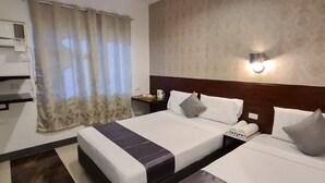 A hotel room with two beds, a nightstand, a lamp, and a window with curtains. - My Stay Hotel - Near SM Mall - 1 min walk (Butuan)
