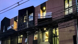 A modern building with a wooden entrance and illuminated signage. - The Nhorm Hotel Ratchada (Bangkok)