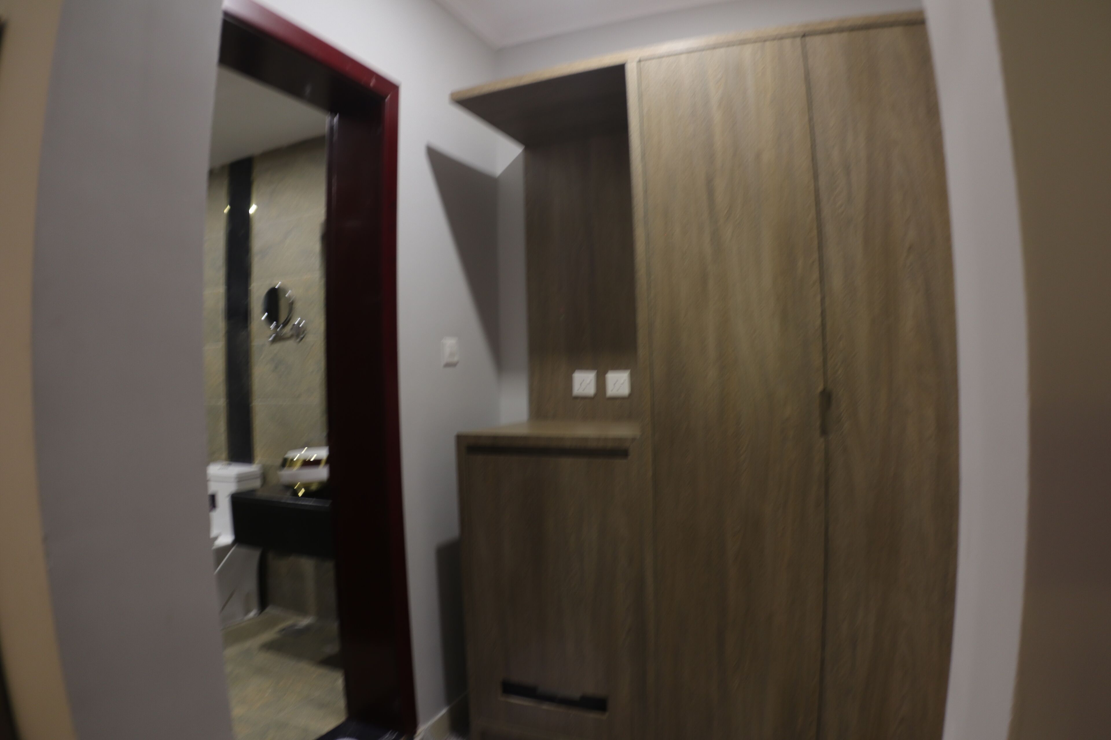 A bathroom with a wooden cabinet, a mirror, and a sink.
