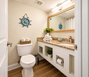 A modern bathroom with a toilet, sink, and mirror.