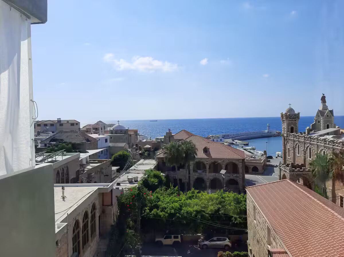 Un pueblo costero con edificios históricos, una iglesia y vistas al mar.