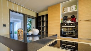 Uma cozinha moderna com bancada preta, armários de madeira e forno embutido.
