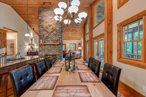 Enjoy meals in this elegant dining area with a long table and comfortable leather chairs.