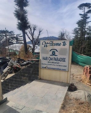 A welcome sign for HARI OM PARADISE, indicating a bed and breakfast offering Himachali country style, culture, and cuisine. - Hari om paradise (Shimla)