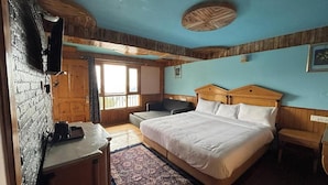 Une chambre à coucher avec un lit, un bureau, une chaise, une fenêtre et un plafond en bois.