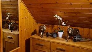 A wooden interior with a mirrored cabinet, a countertop with decorative items, and wooden cabinets. - Idyllic vacation home in the middle of nature (Neunkirchen)