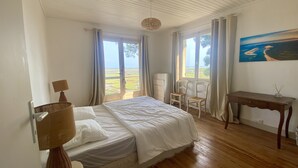 A bedroom with a bed, a desk, a chair, and a painting on the wall. - Villa 10 persons, first line, Lège Cap Ferret (Lège-Cap-Ferret)