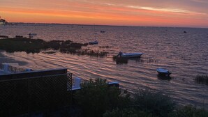 A sunset view from a balcony overlooking a calm sea with several boats anchored. - Villa 10 persons, first line, Lège Cap Ferret (Lège-Cap-Ferret)