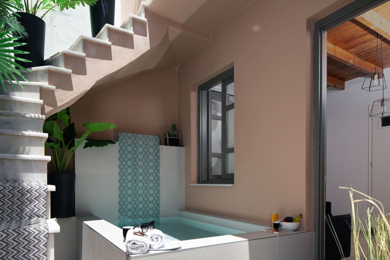 Une salle de bain moderne avec une baignoire sur pieds, une fenêtre et une plante en pot.