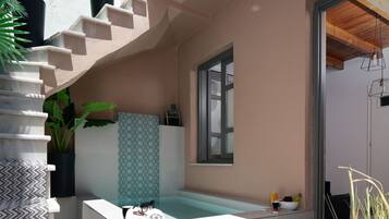 Une salle de bain moderne avec une baignoire sur pieds, une fenêtre et une plante en pot.