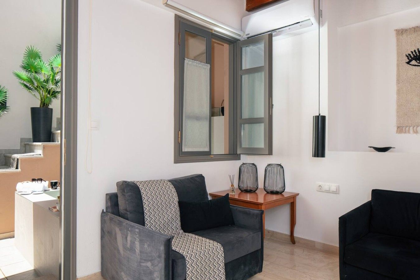 Un salon moderne avec un canapé, une table basse et une grande fenêtre.