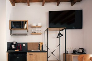 A compact kitchen with a microwave, sink, and a black coffee machine. - Gateway Suites - Harmony (Ρέθυμνο)