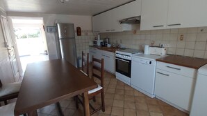 A kitchen with white cabinets, a stainless steel refrigerator, a microwave, a stove, and a dishwasher.