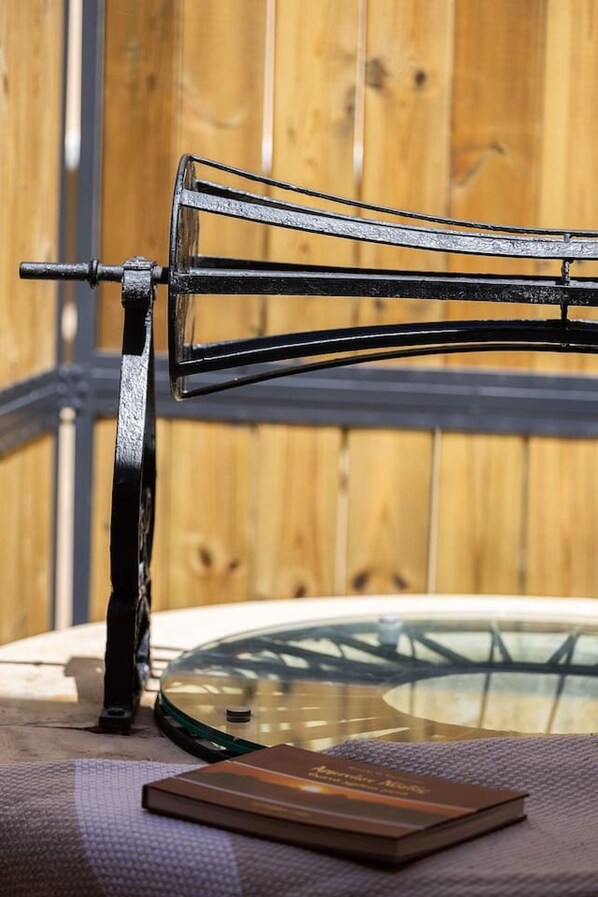 A metal chair with a curved backrest and a table with a glass top.