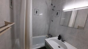 A modern bathroom with a bathtub, a sink, and a shower. - Beachside Retreat: Cozy 1BR Apt with Balcony, WiFi & Parking (Seignosse)