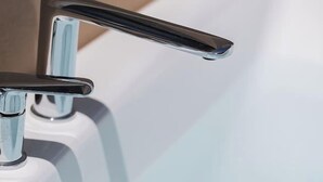 A bathroom sink with a chrome faucet and a mirror.