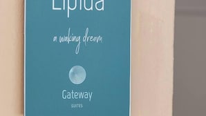 A sign for 'Elpida Gateway Suites' with a logo and a tagline 'a waking dream'.