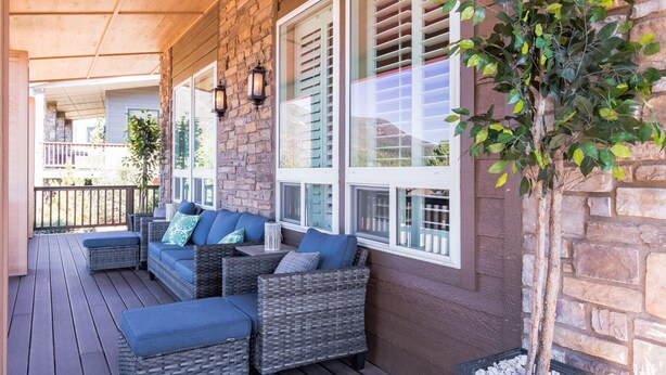 A covered porch with wicker furniture, stone walls, and a potted plant. - 3BR w deck, treetop views, dog friendly (Pine)
