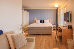 Relax in comfort with a large bed, flat-screen TV, and desk workspace.