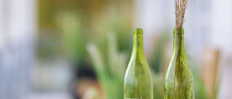 Dos botellas de vidrio con plantas secas sobre una mesa de madera.