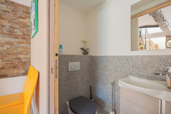 Un baño con ducha, inodoro, lavabo y espejo.