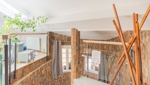 A bathroom with a wooden wall, a mirror, a shower, and a towel rack. - Modern duplex loft in the heart of Annecy's old town for 10 people (annecy)