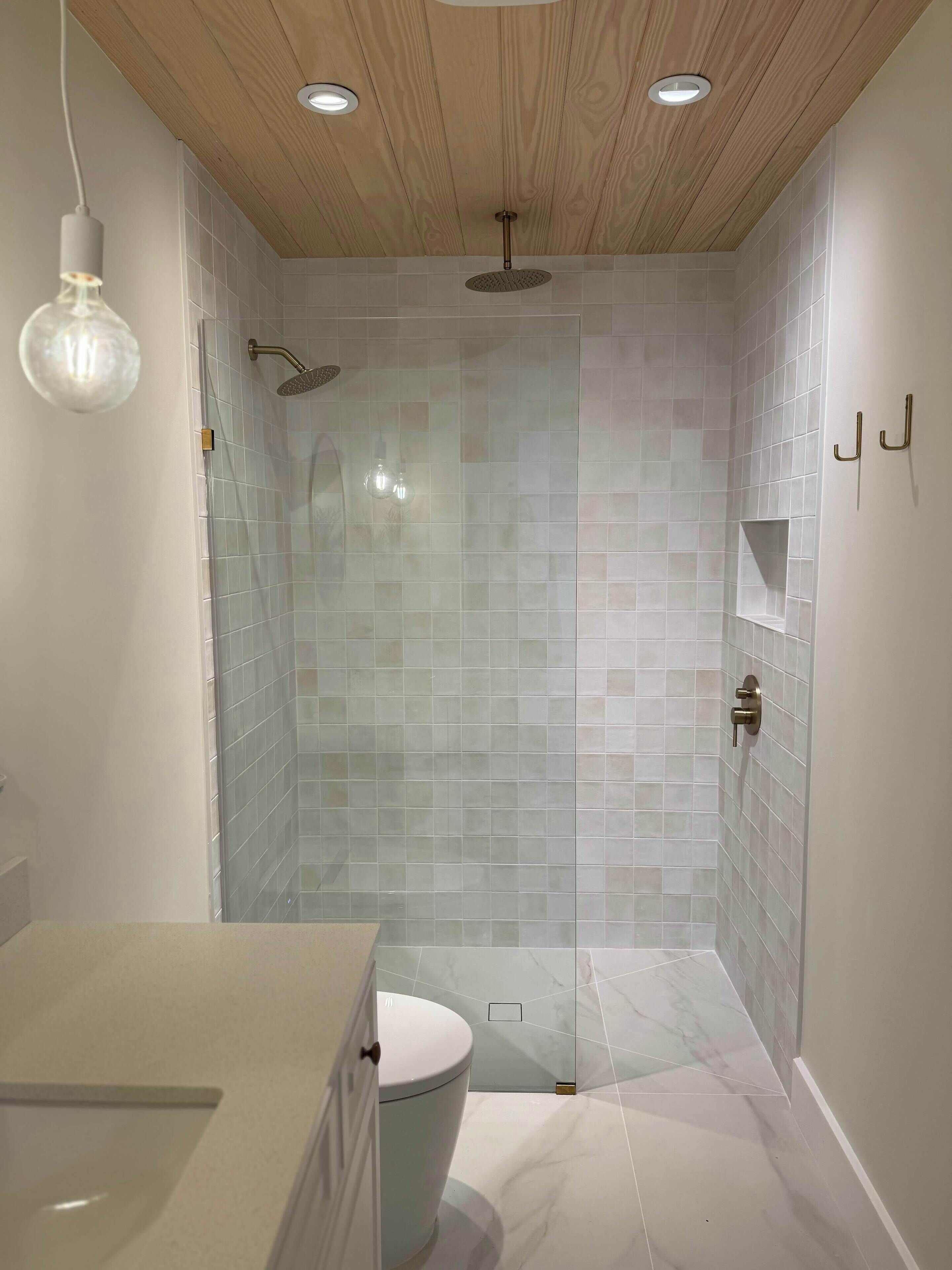 A modern bathroom with a shower, toilet, and vanity.