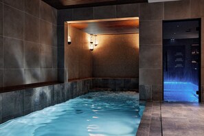 A spa area with a hot tub, tiled walls, and a wooden ceiling. - Le Bellune Paris Hotel & Spa (Paris)