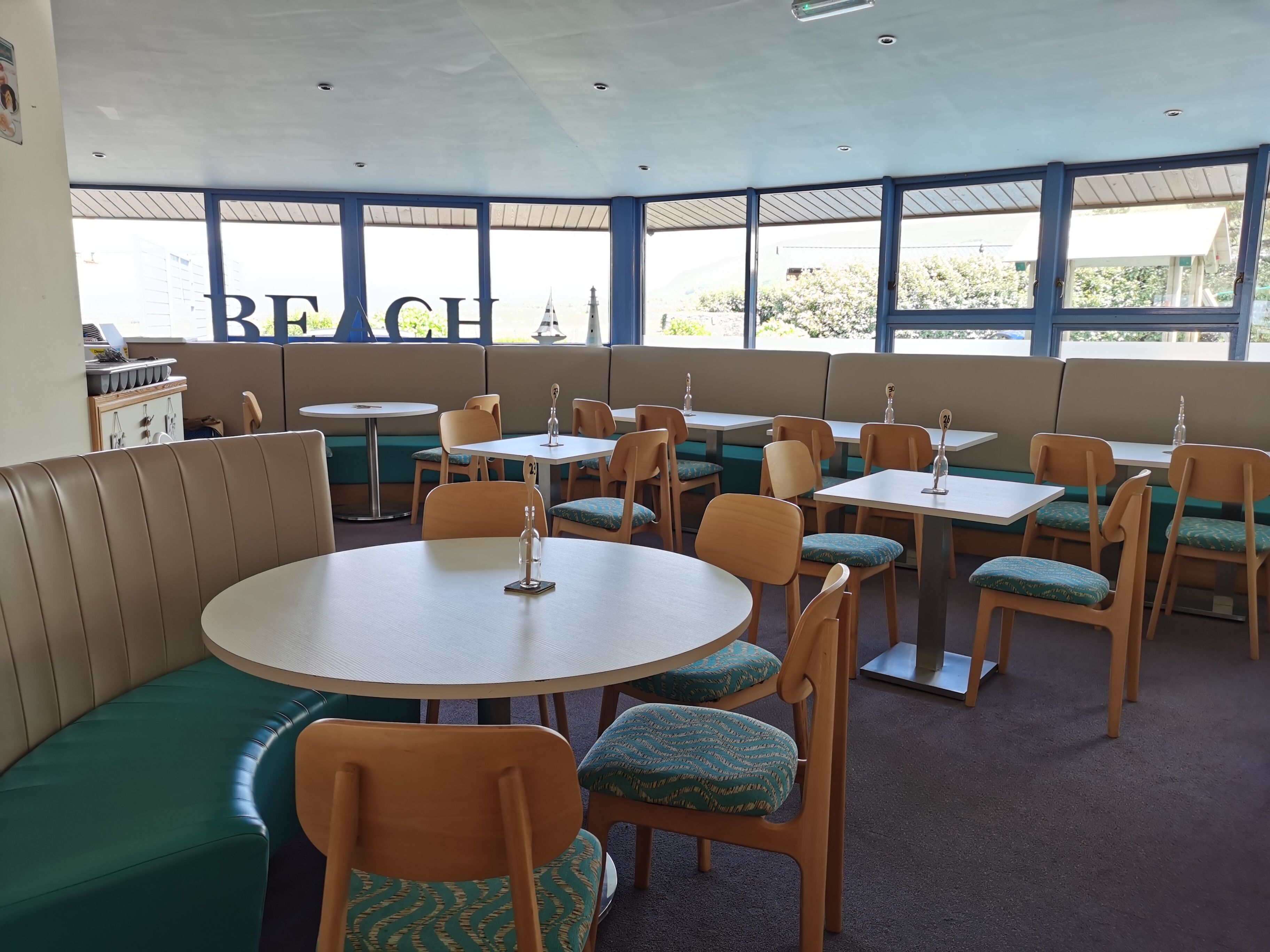 A restaurant with booths, tables, and chairs.