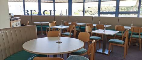 A restaurant with booths, tables, and chairs.