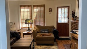 A living room with a sofa, a coffee table, a rug, and a ceiling fan. - Etowah's Cottage - dog friendly, king beds, hiking, rafting, motorcycles (Etowah)