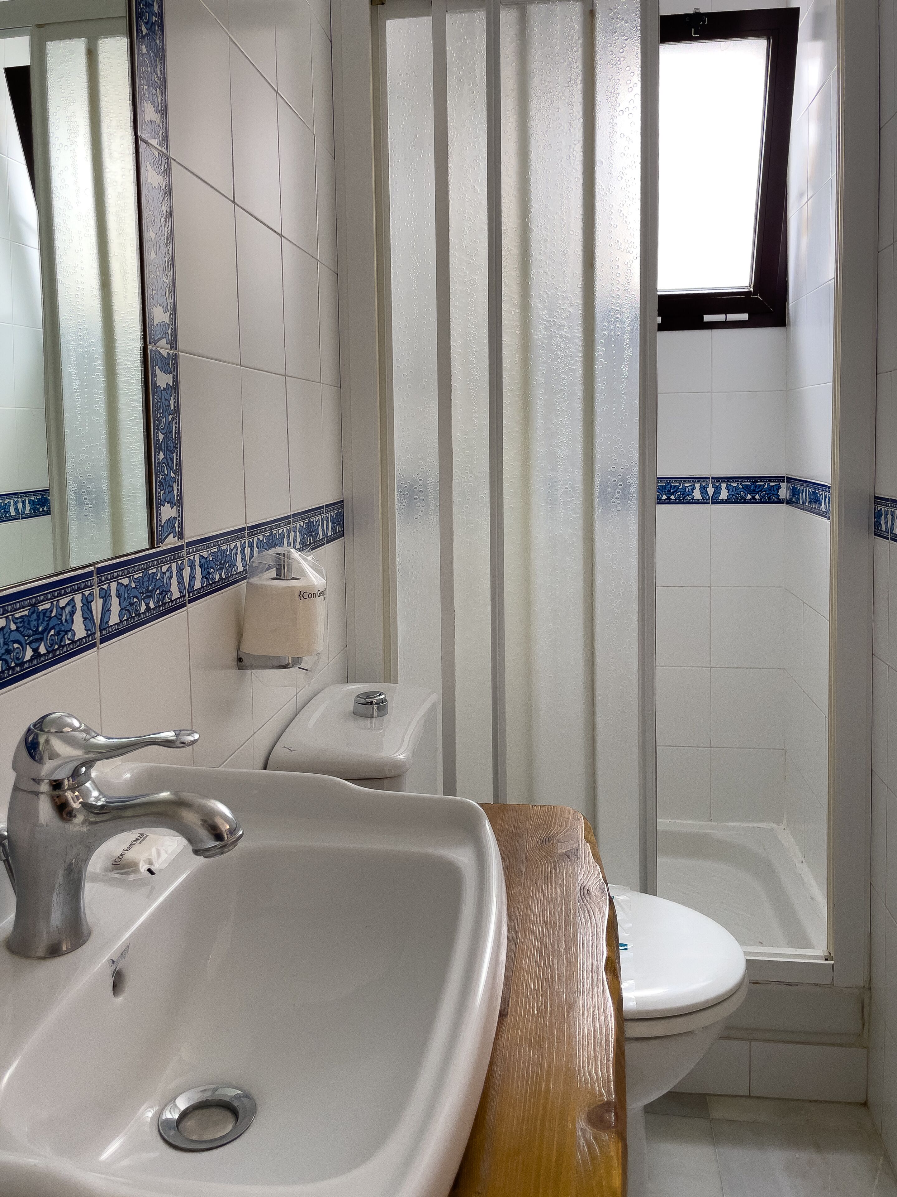 A bathroom with a sink, toilet, and shower area.