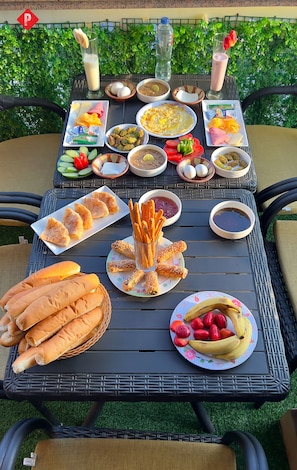 A table set outdoors with various food items and drinks. -  Pyramids View Guest House (Giza)