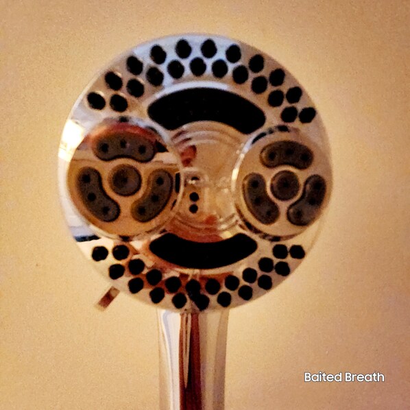 A circular object with a central hole and multiple smaller circular indentations around the edge.