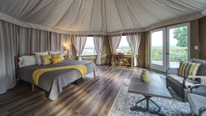 Geräumige Zeltoase mit großem Bett, Essbereich und Sitzecke.