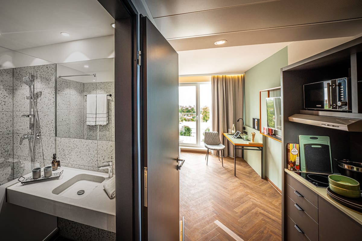 Een moderne badkamer met een groot wastafelmeubel, douche en een douchecabine met glazen wanden.
