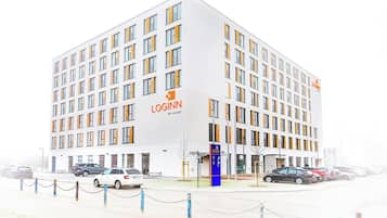 A modern building with a white facade and multiple windows, labeled "LOGINN BY CHAT".
