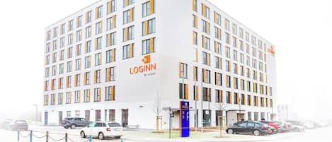 A modern building with a white facade and multiple windows, labeled "LOGINN BY CHAT".