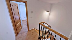 A staircase with wooden handrails and black balusters, leading to an upper floor. - Elegant terraced house in a fantastic south position in Els Poblets (Denia)