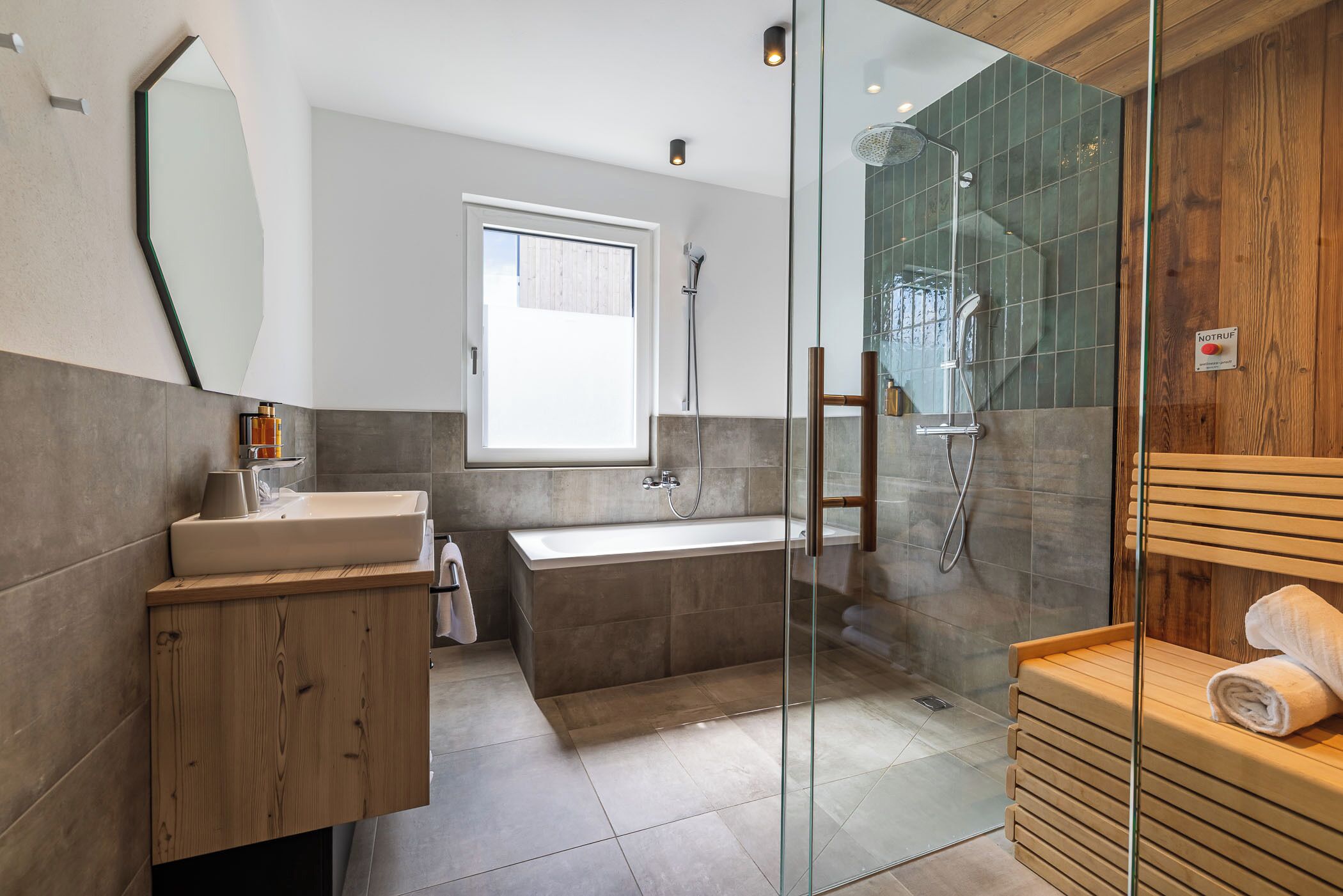 Une salle de bain moderne avec une douche à parois de verre, un meuble-lavabo en bois, une baignoire et un grand miroir.