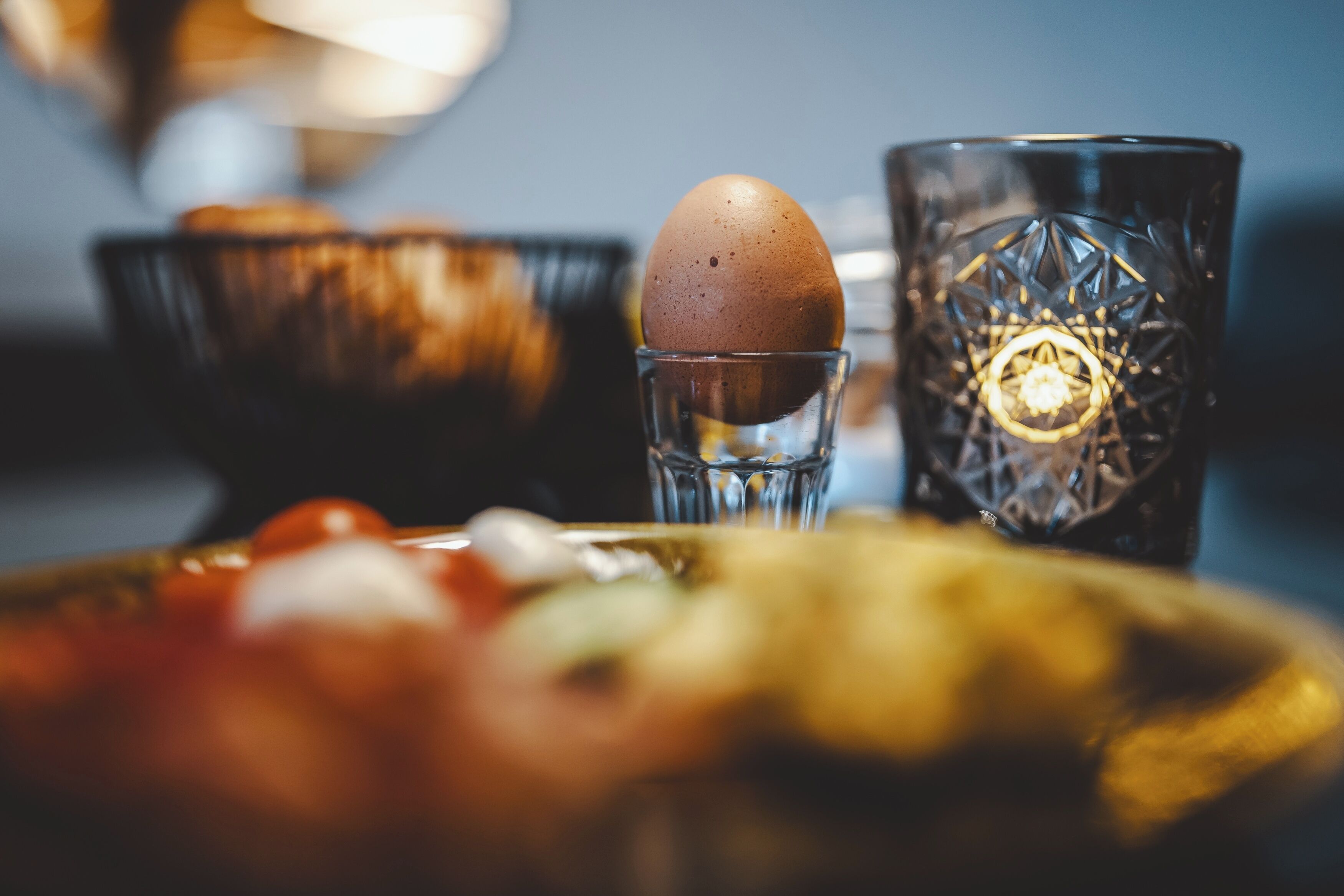 Un gros plan d’un verre orné d’un motif géométrique, dans lequel se trouve un seul œuf.
