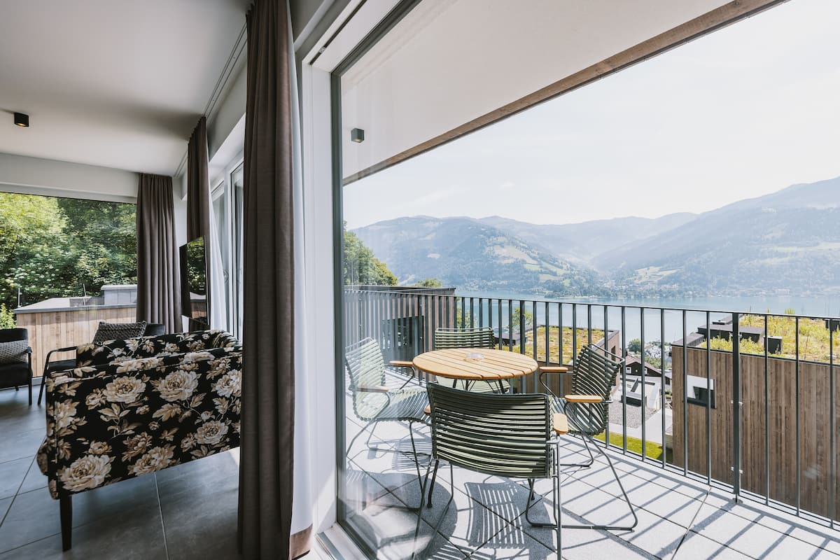 A balcony with a table and chairs, a sofa, and a view of mountains.