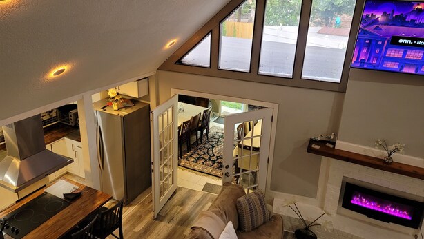 A loft-style living area with a kitchen, dining space, and a fireplace. - Dream house with the capacity of 23 people (Fort Walton Beach)