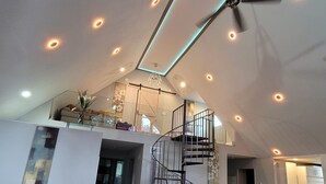 A spacious living area with a high ceiling, a spiral staircase, and a modern kitchen. - Dream house with the capacity of 23 people (Fort Walton Beach)